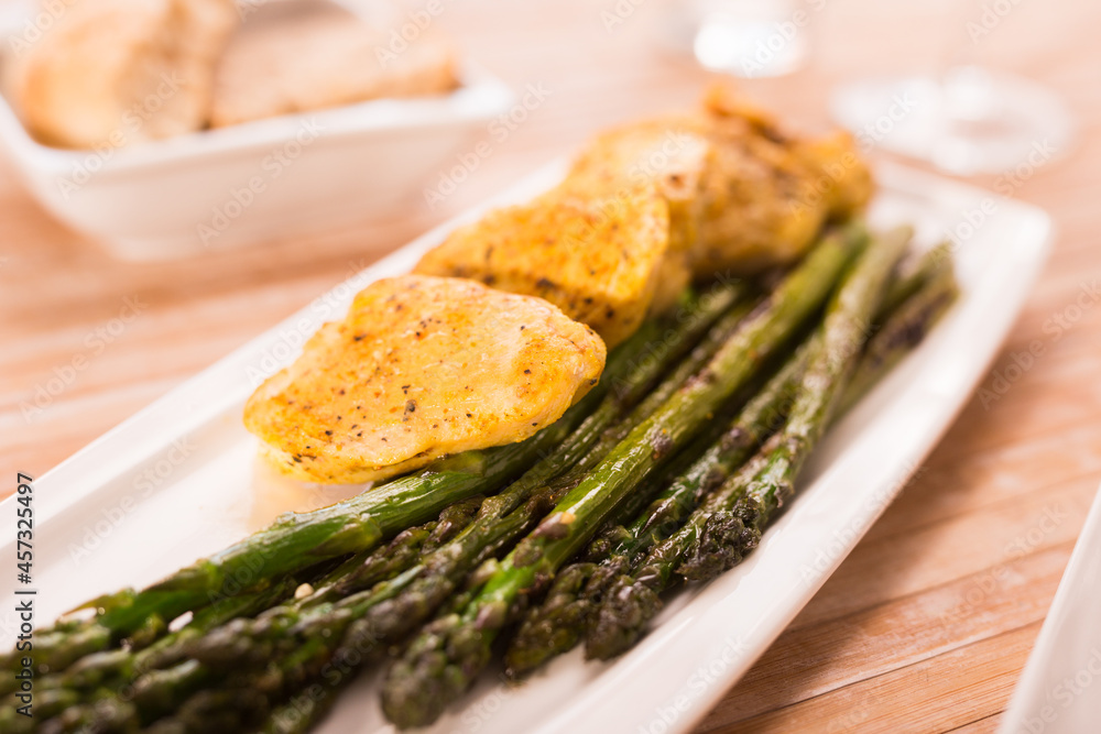 fried chicken breast pieces with asparagus on white plate fried chicken breast pieces with asparagus on white plate