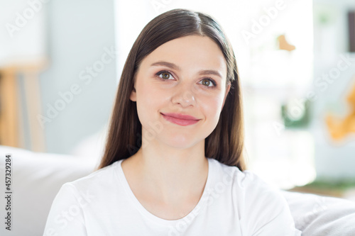 Portrait of attractive cheerful brunette girl sitting on divan spending day daydream calm rest at home indoors