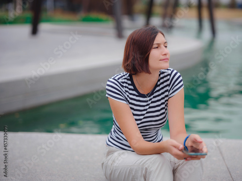 Portrait of beautiful asian young woman in park with smartphone.