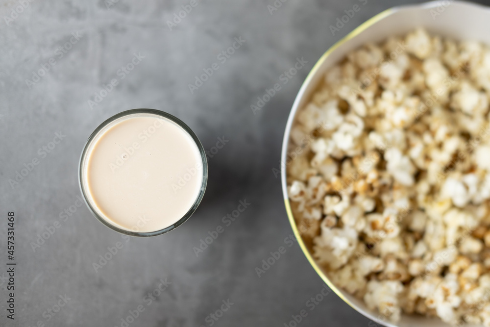 Selective focus on milk tea in glass with a big bowl popcorn Selective focus on milk tea in glass with a big bowl popcorn