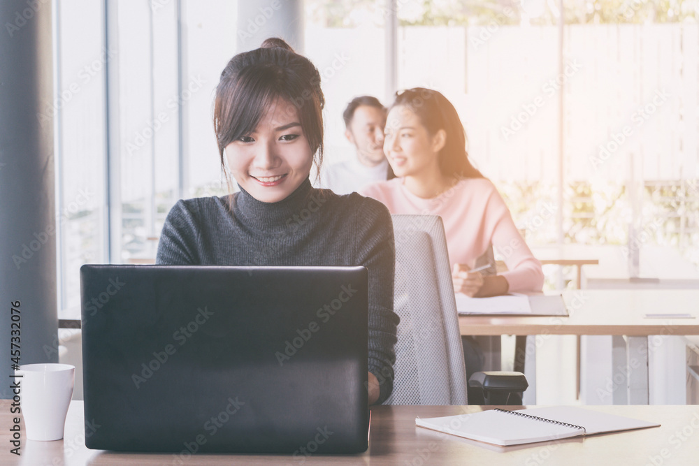 Asian business woman who sitting work by notebook in feeling happy at the office with daylight from window and blur garden background. Asian business woman who sitting work by notebook in feeling happy at the office with daylight from window and blur garden background.