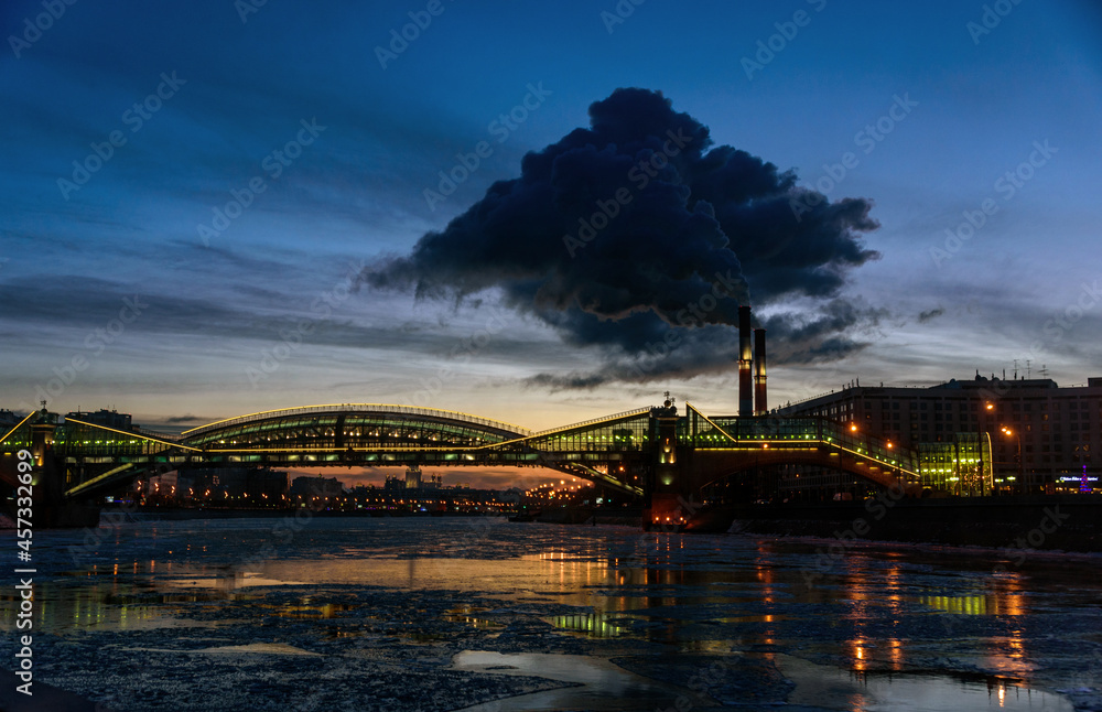 Moscow Cityscape. Evening shot of the Bohdan Khmelnytskyi bridge crossing the Moskva river in Moscow, Russia with an active power plant in the center of the Russian capital. 