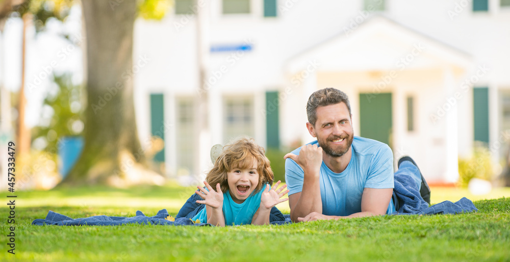 happy father with kid relax together on green park grass, copy space, family day happy father with kid relax together on green park grass, copy space, family day