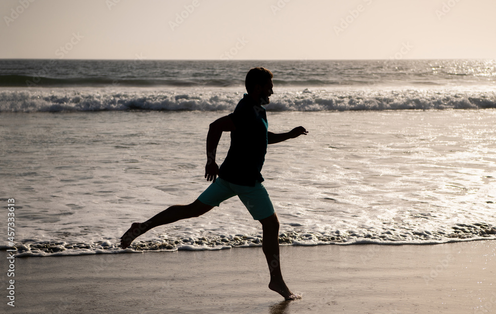 morning workout activity. sporty man running on beach. energetic summer. runner feel freedom