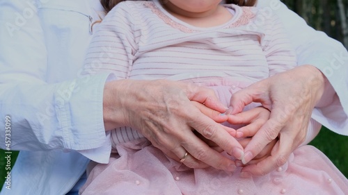 Heart from the hands of grandmother and granddaughter. The concept of a happy relationship between generations, raising children