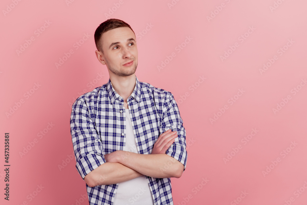 Portrait of attractive young man standing with folded hand dream look empty space confident isolated on pink color background Portrait of attractive young man standing with folded hand dream look empty space confident isolated on pink color background