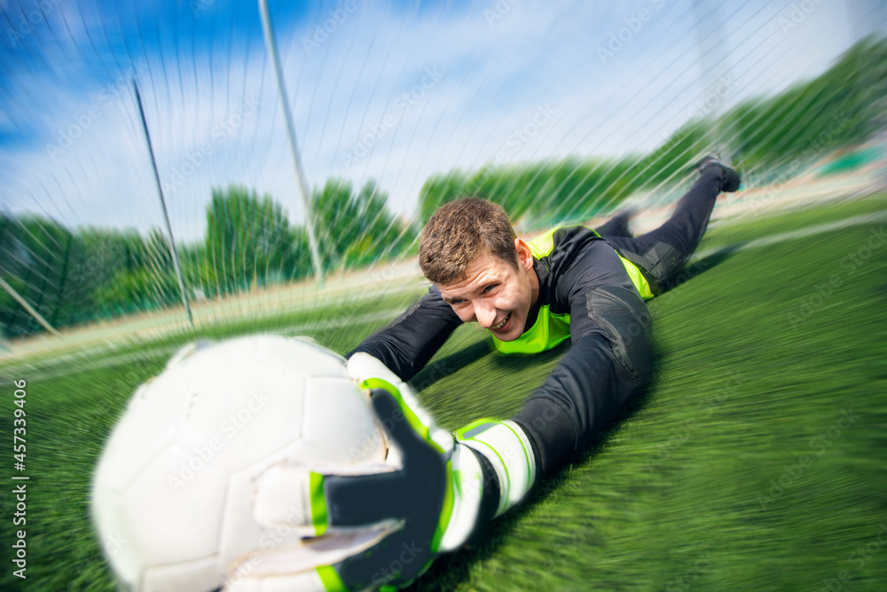 Goalkeeper soccer man catching ball in stadium, action moment of sport Goalkeeper soccer man catching ball in stadium, action moment of sport