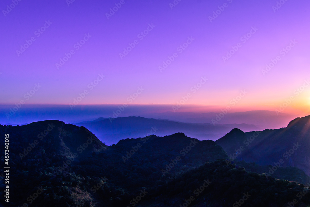 A stunning sunset or sunrise scene of silhouette mountain peaks and purple ridges with the twilight background, the blue sky and the pink-yellow skyline, captured at chiangmai, thailand A stunning sunset or sunrise scene of silhouette mountain peaks and purple ridges with the twilight background, the blue sky and the pink-yellow skyline, captured at chiangmai, thailand