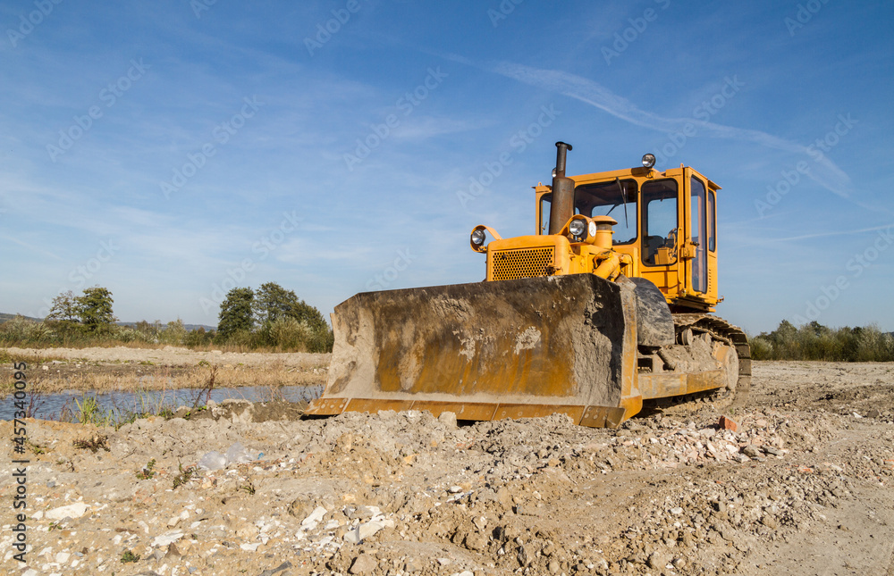 Large yellow bulldozer (dozer or crawler) on a construction site. Large yellow bulldozer (dozer or crawler) on a construction site.