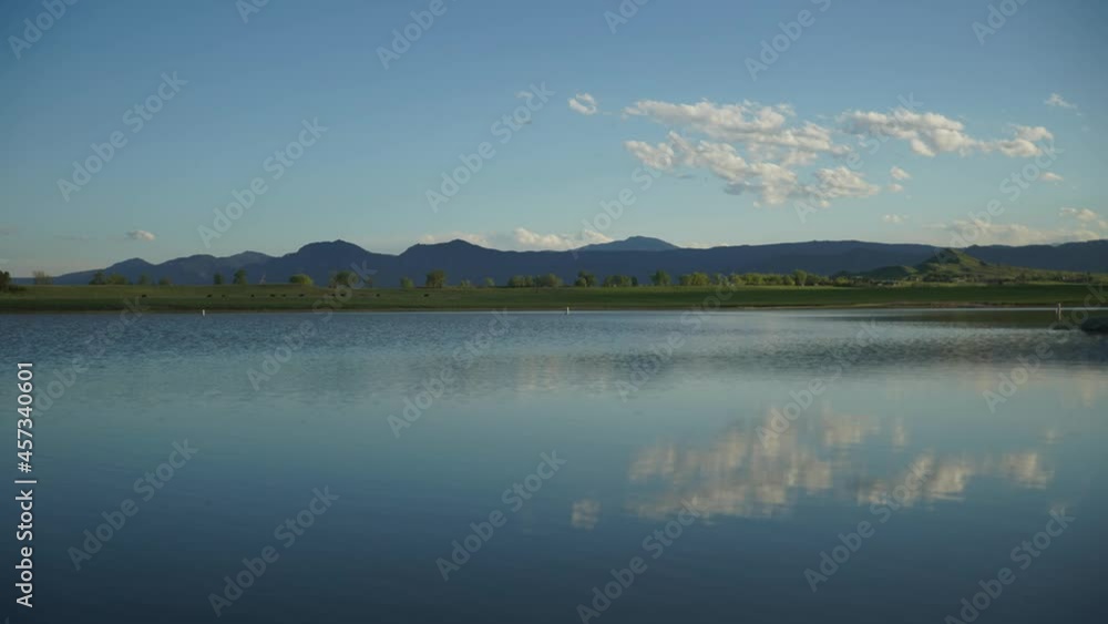 Time lapse of clouds floating over rolling hills and water Time lapse of clouds floating over rolling hills and water