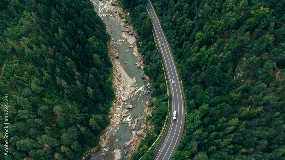 Beautiful aerial view of the road with mountains and forest, road and river, shot from above, carpathians, Ukraine