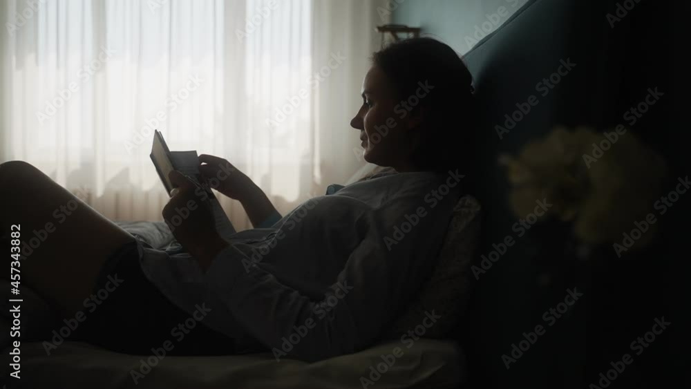 Woman enjoys reading a book in the bedroom. Woman enjoys reading a book in the bedroom.