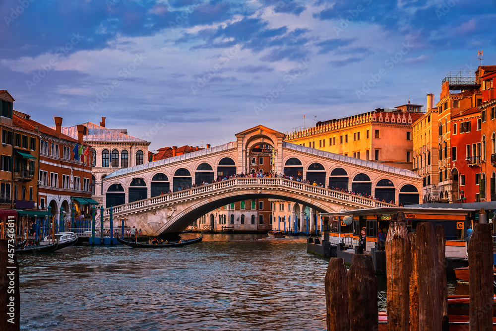 Sunset view of famous bridge of Rialto or ponte di Rialto over Grand Canal, Venice, Italy. Iconic travel destination of UNESCO world heritage city
