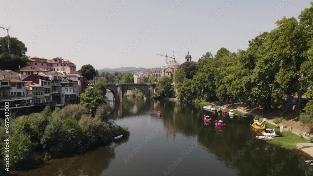 Amarante town skyline with ancient stone bridge and many modern animal boats in river water, aerial view Amarante town skyline with ancient stone bridge and many modern animal boats in river water, aerial view