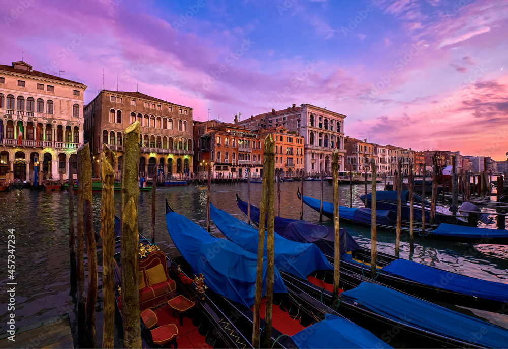 Sunset view of Grand Canal, Venice, Italy. UNESCO heritage city famous for its waterways and gondolas, beautiful sunset sky and evening lights