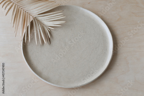 Ceramic plate on a wooden table top view. minimalist handmade ceramic tableware and pottery