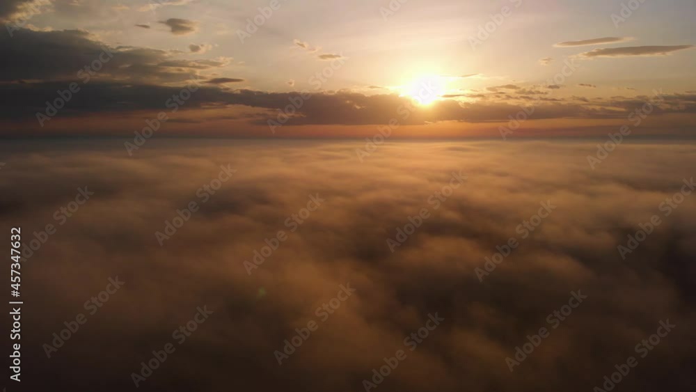 Flying over the clouds. Beautiful sunrise or sunset over the clouds. Orange sky. Beautiful sunrise landscape with morning mist. Aerial view. Colorful sky background Flying over the clouds. Beautiful sunrise or sunset over the clouds. Orange sky. Beautiful sunrise landscape with morning mist. Aerial view. Colorful sky background