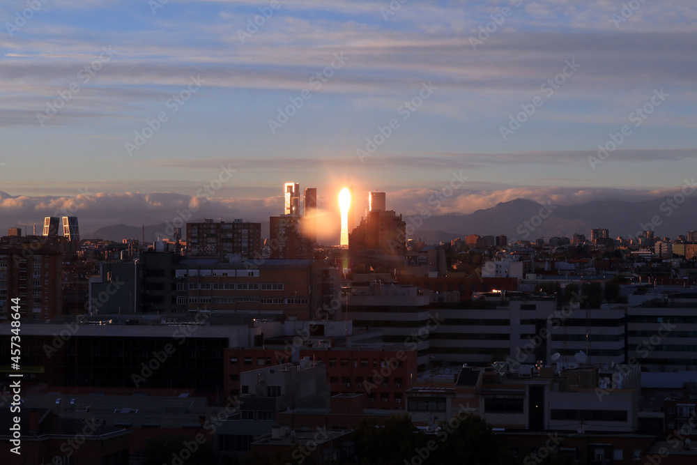 Fototapeta premium paisaje de ciudad al atardecer dando el reflejo del sol en los edificios
