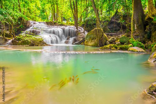 Waterfalls and fish swim in the emerald blue water in Erawan National Park. Erawan Waterfall is a beautiful natural rock waterfall in Kanchanaburi  Thailand.Onsen atmosphere. 