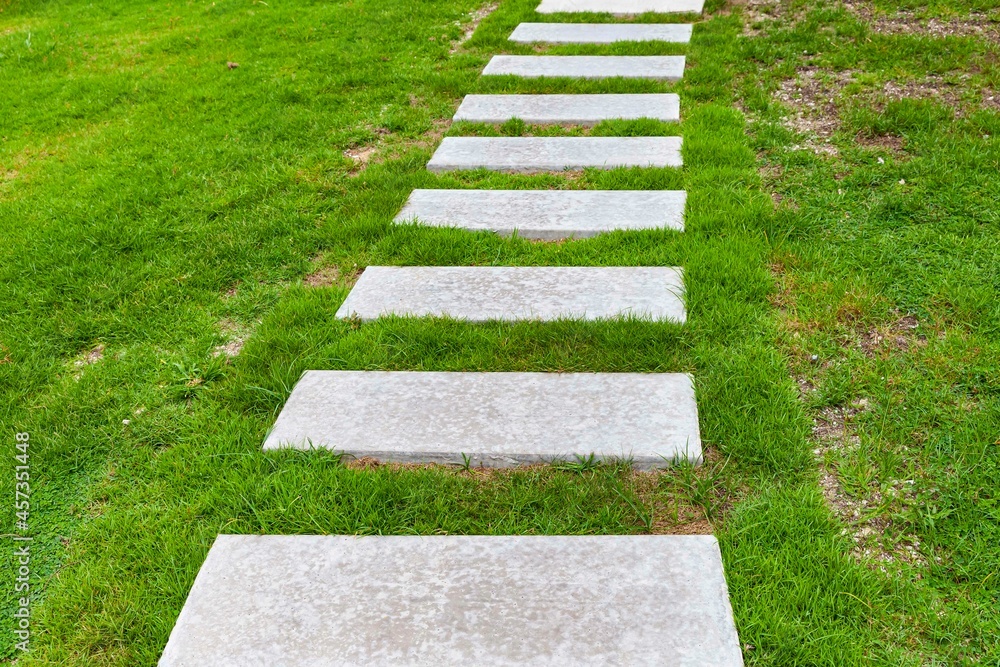 White granite walkway slabs patterned in green lawns at the garden