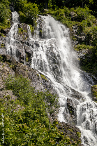Wasserfall mit Felsen und gr  nen B  umen