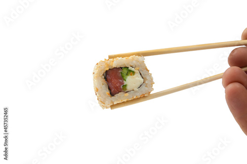 a woman's hand holds sushi with wooden sticks close-up,isolated on white