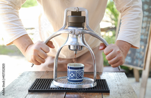 hands showing making espresso coffee ahot from machine in drinking style photo