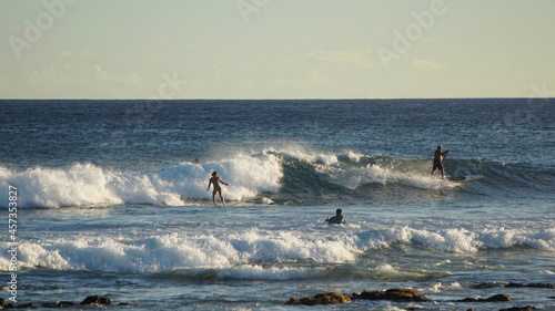 Surfers ride the waves off Waiohai Beach on the south shore of Kauai.
