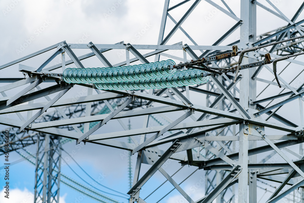 View of huge electric supply. Big electricity construction at the blue cloudy sky background. Low angle view. Stock photo View of huge electric supply. Big electricity construction at the blue cloudy sky background. Low angle view. Stock photo