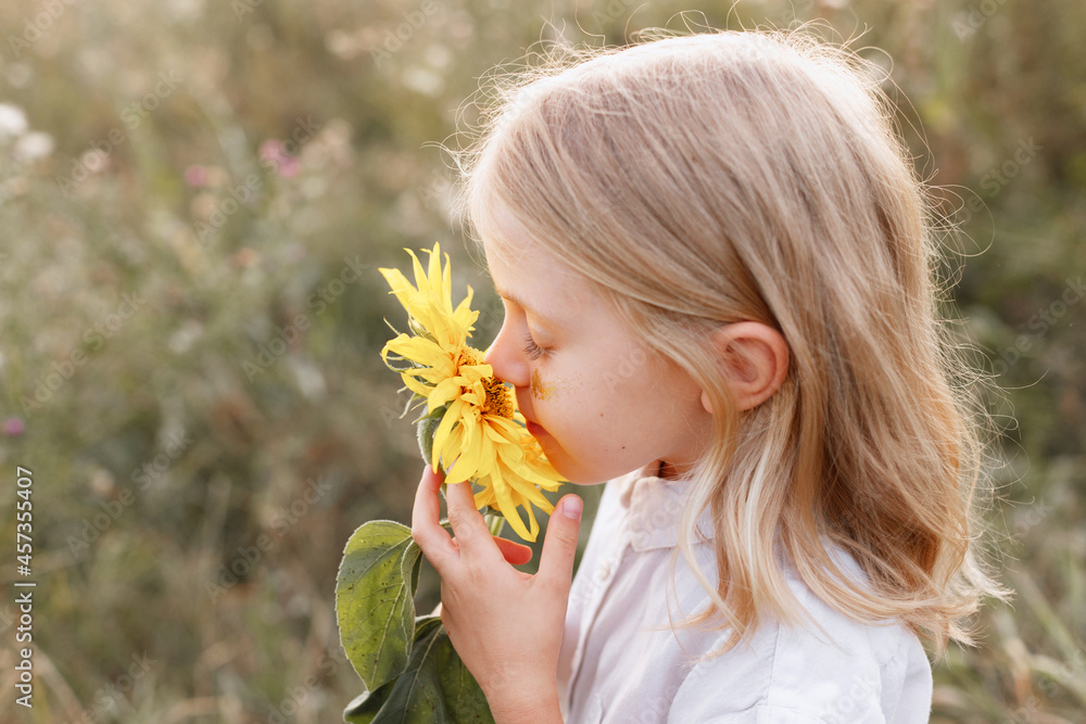 a little girl sniffs a yellow flower. close-up a little girl sniffs a yellow flower. close-up