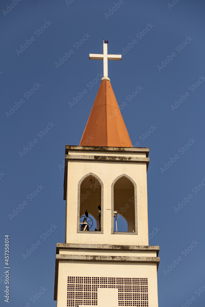 Detalhe da fachada da Paróquia de São Benedito na cidade de Nerópolis com céu azul ao fundo.