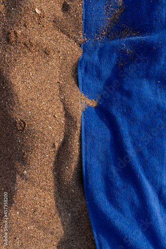 Texture of sand and towel cloth, of intense color, extended to the sun, on Arrigunaga beach, near Bidezabal, Basque Country, Spain photo