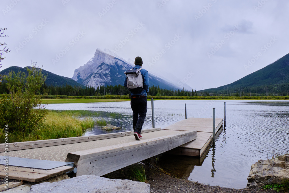 Pier on Vermillion lake with man and in the background mountain Rundle 1, Banff National Park Pier on Vermillion lake with man and in the background mountain Rundle 1, Banff National Park