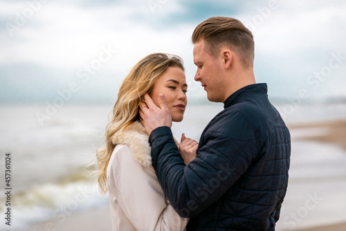 Two Young couple standing enjoying on a coast and enjoying each other.Summer,spring,autumn vacation.