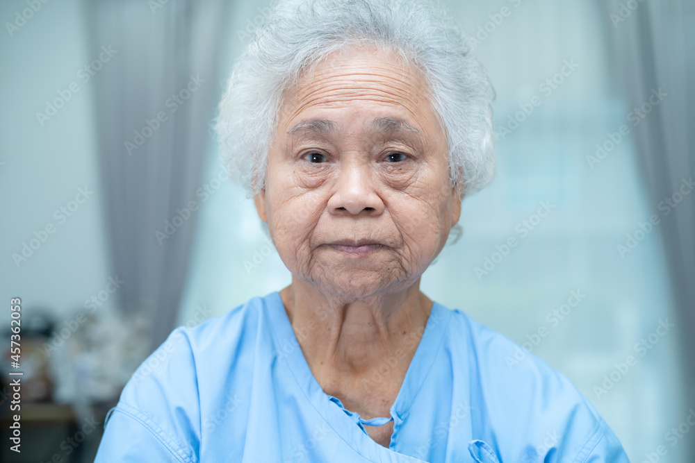 Asian senior or elderly old lady woman patient bright face while sitting in  nursing hospital ward, healthy strong medical concept. Stock Photo