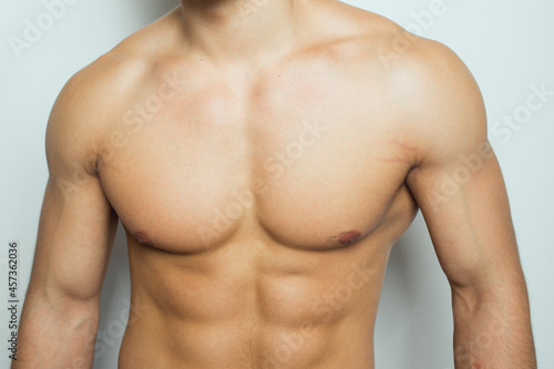 the torso of a young athletic guy. concept: the male body after exercise and diet. men's health: shaved breasts photo