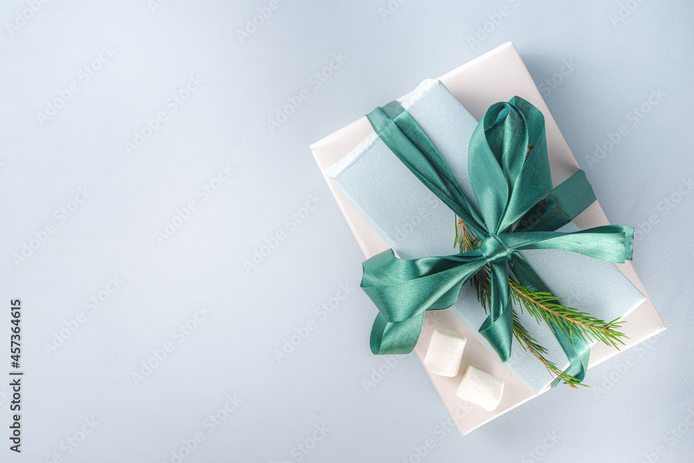 Big stack of Christmas gifts with hot chocolate, stay on it like pedestal, cozy pastel colored craft paper gift boxes with green festive Xmas ribbon, cup of cocoa with marshmallow, copy space Big stack of Christmas gifts with hot chocolate, stay on it like pedestal, cozy pastel colored craft paper gift boxes with green festive Xmas ribbon, cup of cocoa with marshmallow, copy space