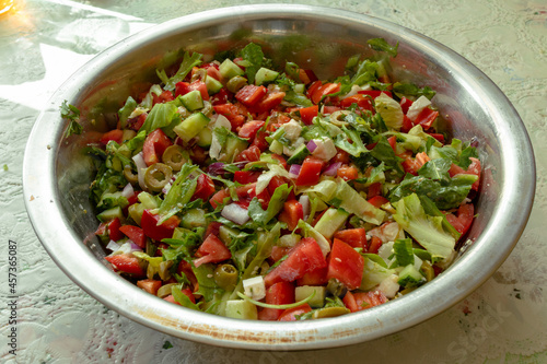 Salad with olives, lettuce, tomatoes, paprika, onions and Mozzarella cheese. Greek salad in a large bowl