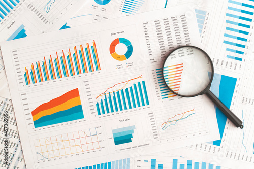 Obraz na płótnie Business graphs, charts and magnifying glass on table. Financial development, Banking Account, Statistics w salonie