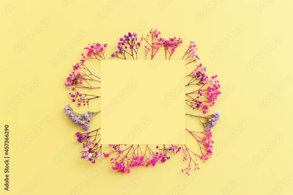 Top view image of pink and purple flowers composition over pastel yellow background .Flat lay Top view image of pink and purple flowers composition over pastel yellow background .Flat lay
