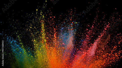 Freeze motion shot of color powder explosion isolated on black background, close-up.