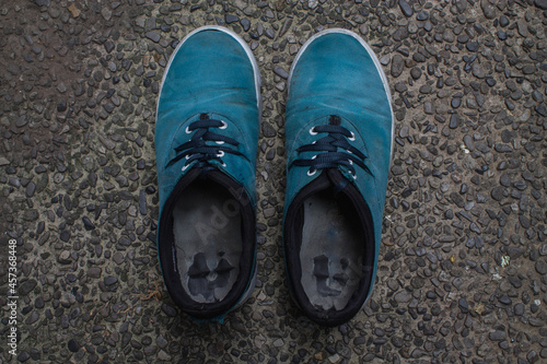 A pair of dirty and torn shoes.