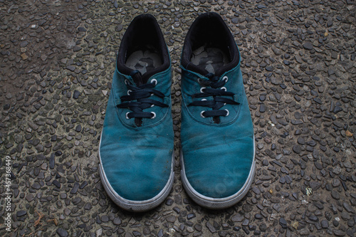 A pair of dirty aquamarine shoes.