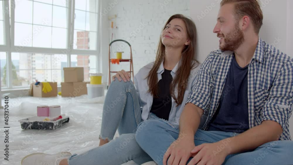 Couple taking a break and happy with the work as they decorate а room in their new home. Happy couple in love painting their first apartment together. 4k Couple taking a break and happy with the work as they decorate а room in their new home. Happy couple in love painting their first apartment together. 4k