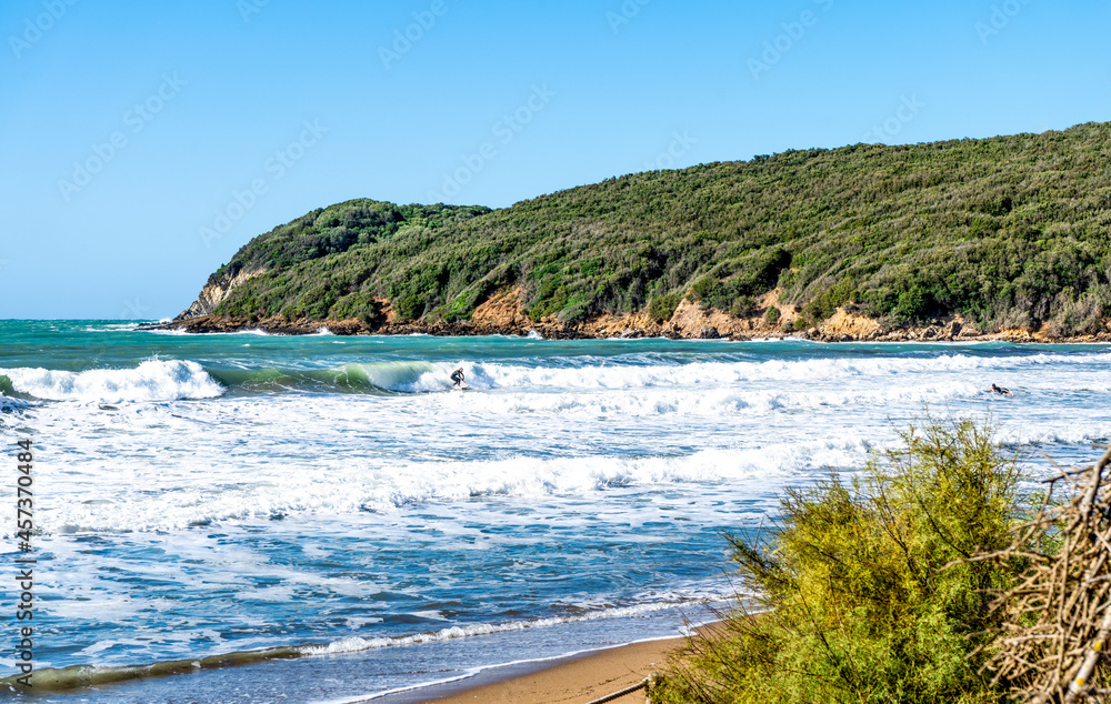 Φωτογραφία A surfer swimming in the waves with his surfboard, in the gulf of Baratti, Piombino, province of Livorno, Italy