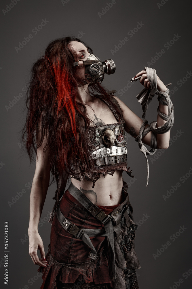 Attractive young woman with red eyes wearing post apocalyptic