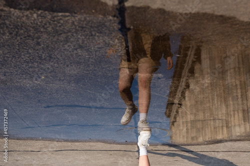 Reflection of a girl running in a puddle photo