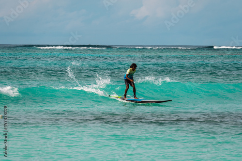 A surfer rides a board on the waves of the ocean. Water adventures in the tropics. © Сергей Петросянц