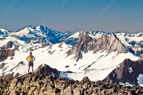 Fit attractive strong and active female backpacker on mountain summit photo