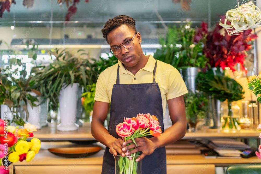 © Cavan Images - young african entrepreneur looking at the flowers of his business © Cavan Images - young african entrepreneur looking at the flowers of his business